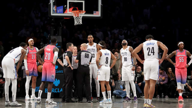 Referees huddle to discuss a foul by Washington Wizards forward Deni Avdija (9) and a goaltending by Wizards center Daniel Gafford (21) against Brooklyn Nets guard Cam Thomas (24) during the fourth quarter at Barclays Center.